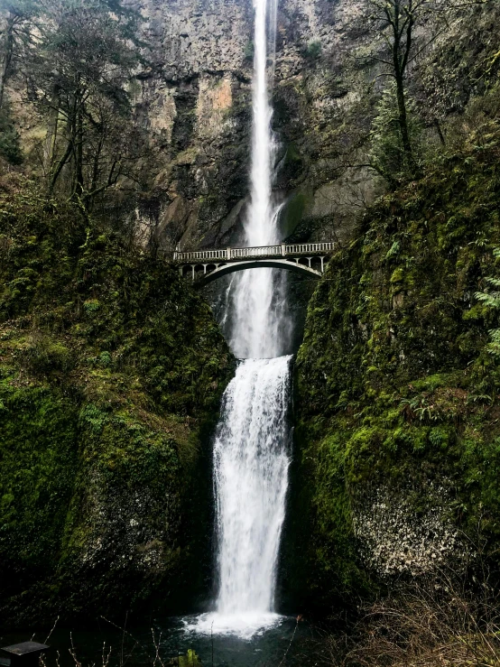 a waterfall with a bridge in the middle of it, cascadia, promo image, thumbnail, stacked image