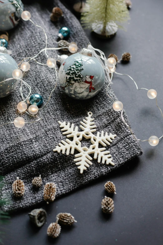 a table topped with christmas decorations on top of a table, dark grey, snowflakes, up close, detaling