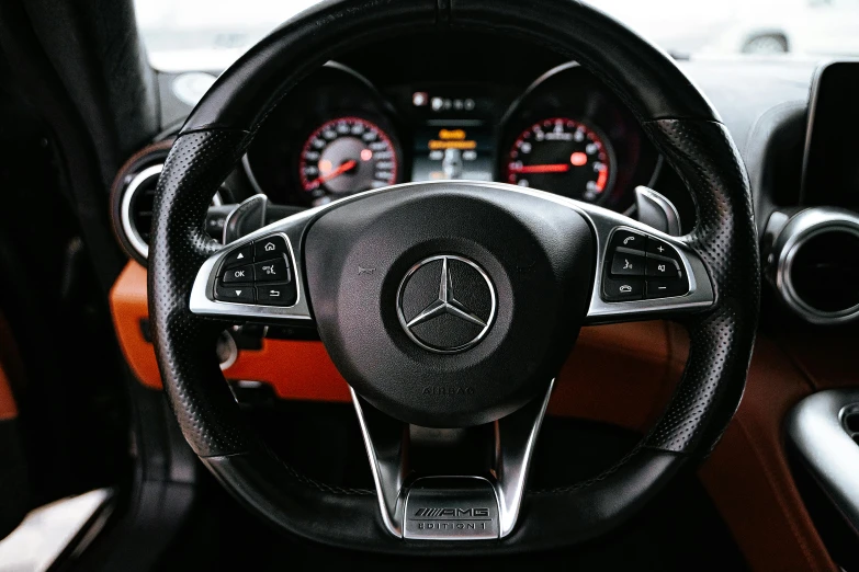 a close up of a steering wheel in a car, mercedez benz, black and orange, instagram post, shot on sony a 7