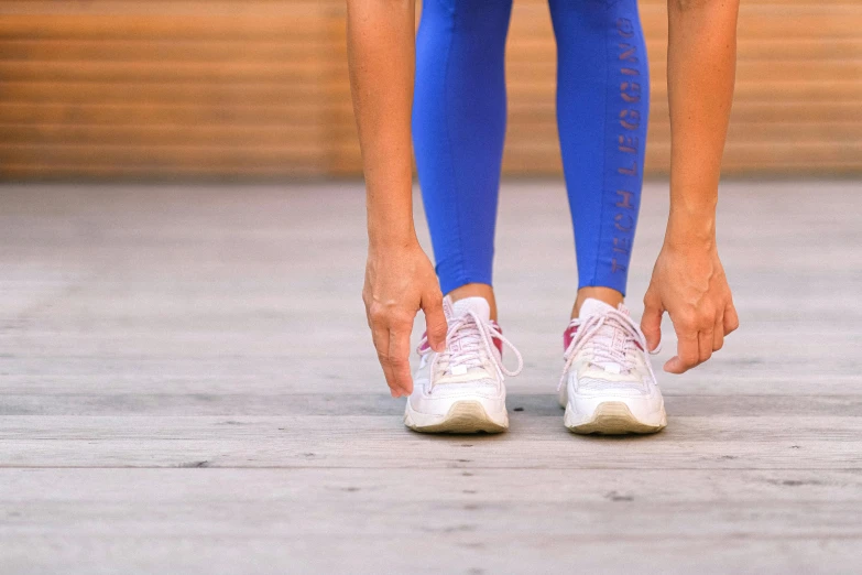 a close up of a person tying their shoes, trending on pexels, two piece workout clothes, thumbnail, running sequence, hand on hip