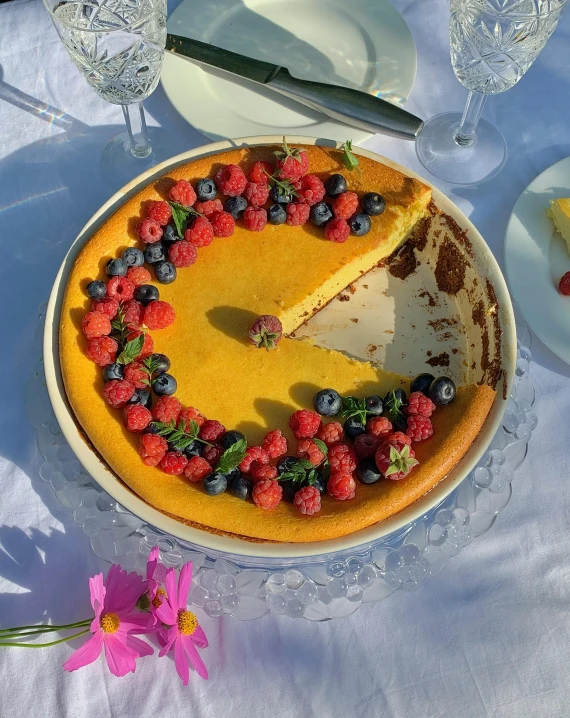 a pie with a slice taken out of it sitting on a table, made of flowers and berries, 🚿🗝📝, sunny light, thumbnail