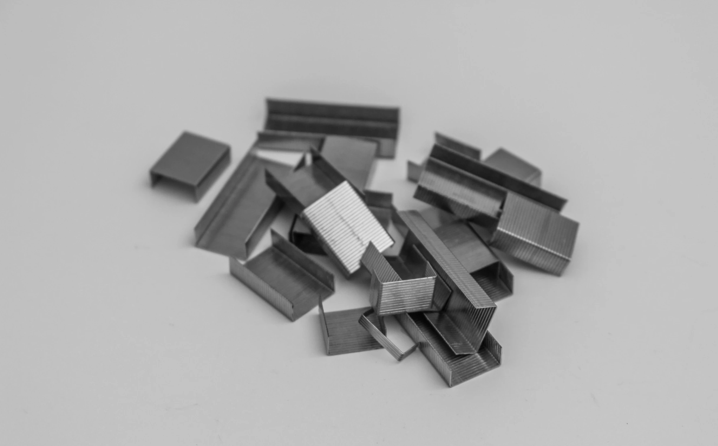 a pile of metal pieces sitting on top of a table, an engraving, by Julian Fałat, unsplash, bauhaus, staples, 10 mm, rectangles, highly detailed product photo