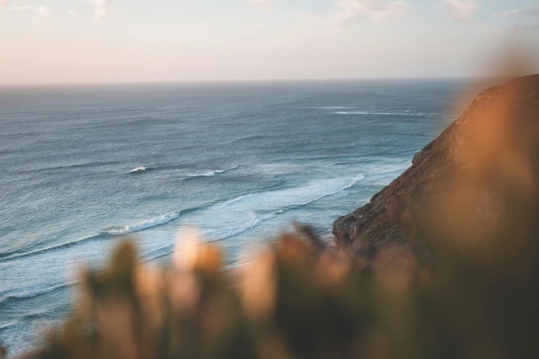 a view of the ocean from the top of a hill, pexels contest winner, surf photography, afternoon hangout, steep cliffs, sunfaded