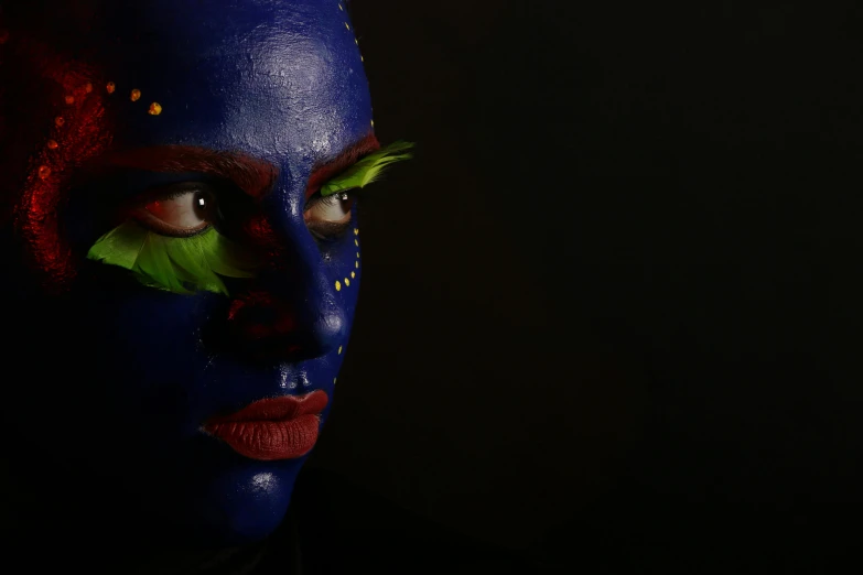 a close up of a person with a painted face, inspired by Yves Klein, pexels contest winner, afrofuturism, on black background, the blue panther, colored photo, fullbody painting