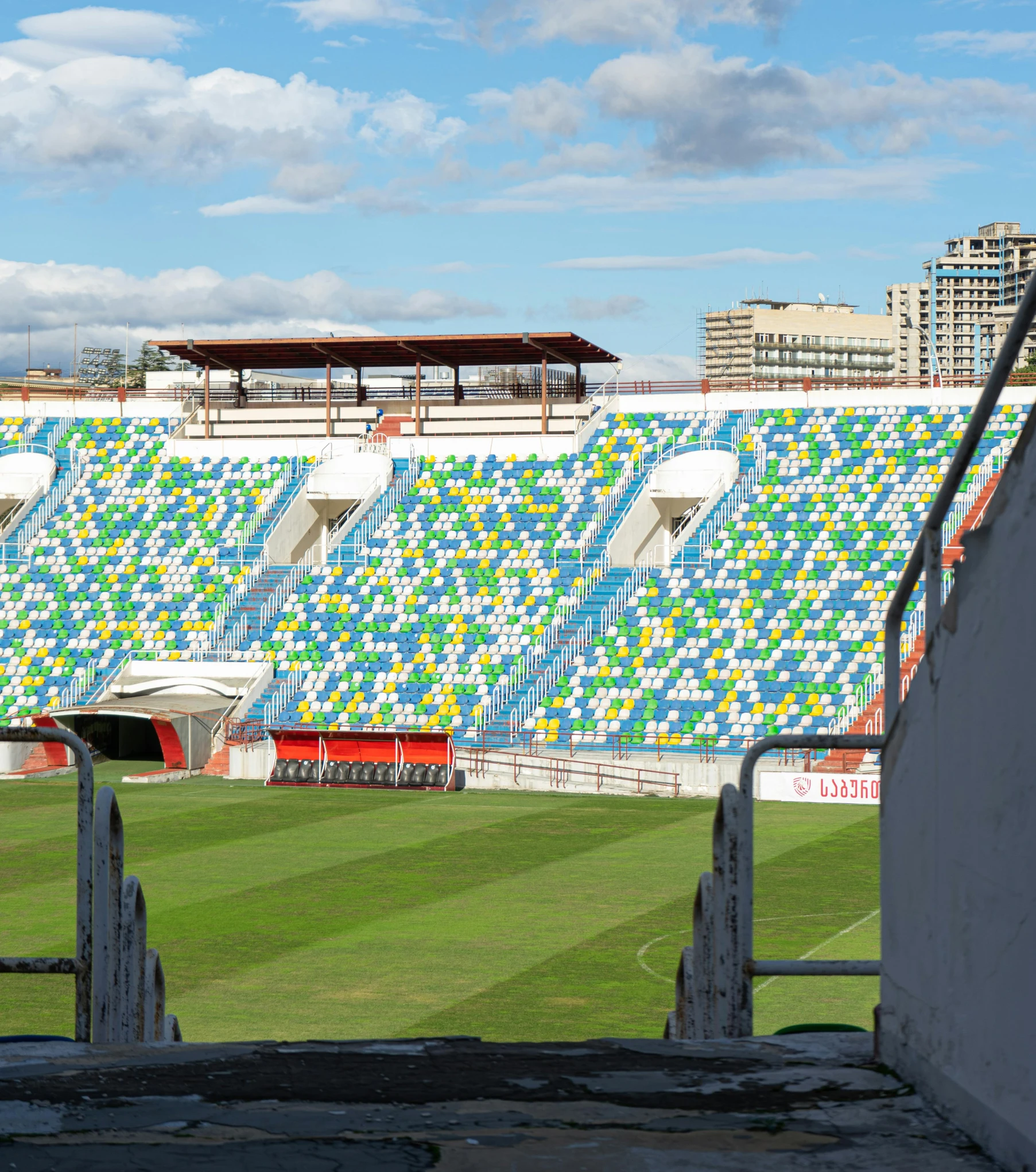 a man riding a skateboard on top of a green field, a mosaic, inspired by Oswaldo Viteri, crowded stands, freddy mamani silvestre facade, terraced, seen from afar