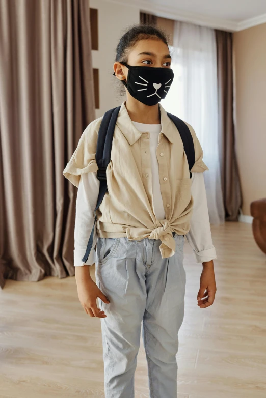 a young boy standing in a living room wearing a mask, by Nina Hamnett, shutterstock, wearing a linen shirt, catwalk, school, wearing bandit mask