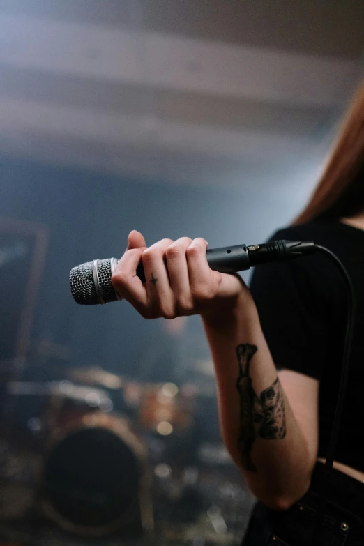 a woman that is holding a microphone in her hand, shutterstock, antipodeans, rock band, museum quality photo, heavy metal, no - text no - logo