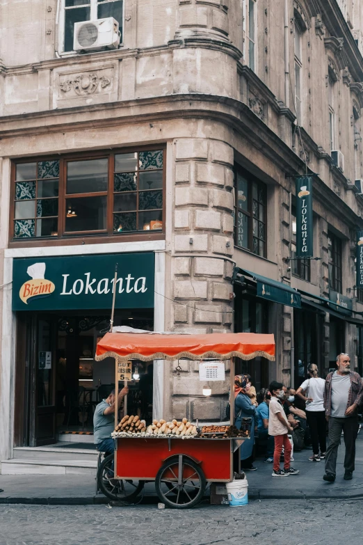 a group of people walking down a street next to a building, by Dóra Keresztes, trending on unsplash, polish food, loki, shop front, loreta lux