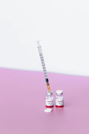 a syll sitting on top of a pink table, syringe, detailed product image, getty images, coronavirus