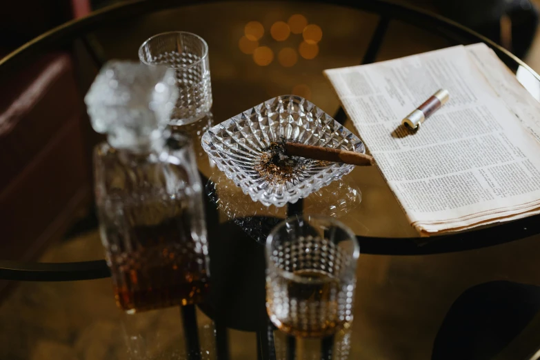 an open book sitting on top of a glass table, inspired by William Grant Stevenson, trending on unsplash, renaissance, cigar, intricate set, glass tableware, detail shot