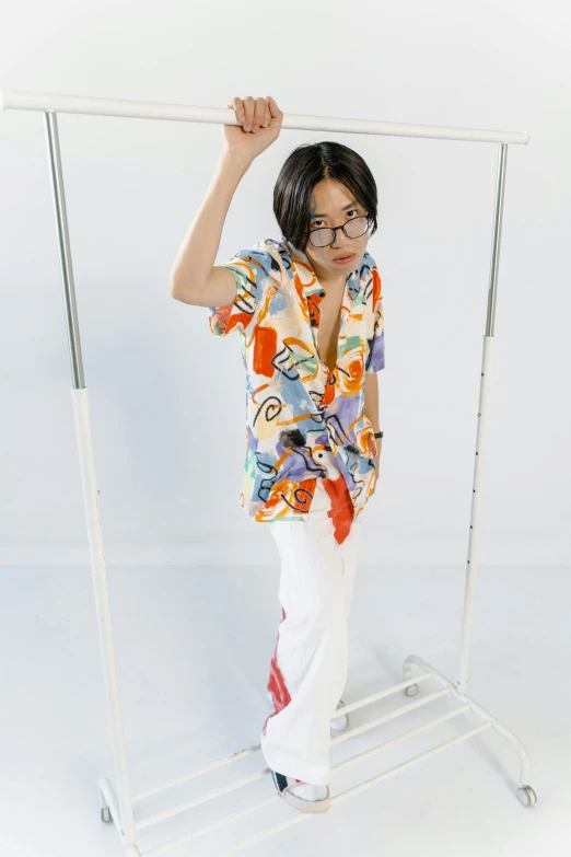 a woman standing in front of a clothes rack, by Oka Yasutomo, unsplash, process art, with hawaiian shirt, teenage boy, on white background, summer color pattern