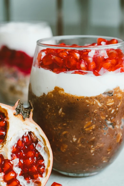 a couple of desserts sitting on top of a table, fruit, bowl filled with food, pomegranate, daytime