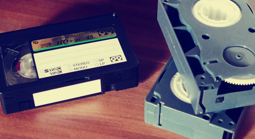 a couple of cassettes sitting on top of a wooden table, inspired by John E. Berninger, unsplash, video art, vhs filter, historical archive, instagram post, 1 9 8 0 s tech