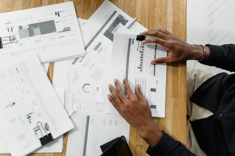 a person sitting at a table with papers and a cell phone, curated collections, engineering, thumbnail, flatlay