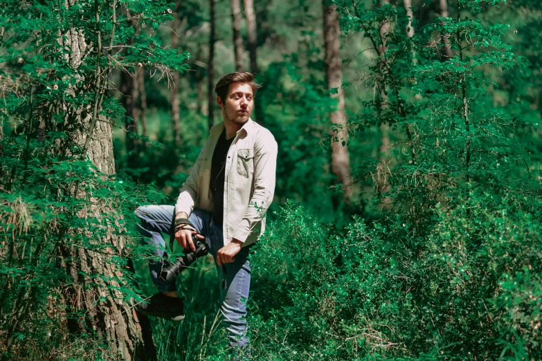 a man standing next to a tree in a forest, a portrait, unsplash, renaissance, cinematic outfit photo, camera photo, wearing a linen shirt, tv still