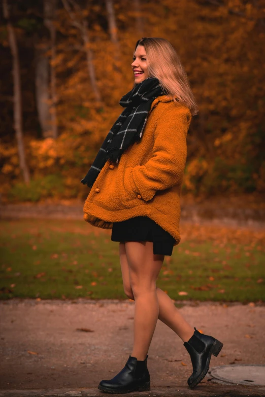 a woman walking down a sidewalk in a park, by Sven Erixson, pexels contest winner, wearing honey - themed miniskirt, warm cosy colors, 15081959 21121991 01012000 4k, wearing fluffy black scarf