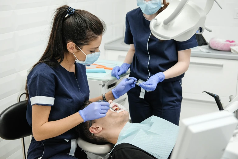 a man getting his teeth examined by a dentist, pexels contest winner, hurufiyya, surgical gown and scrubs on, melbourne, round portruding chin, burned