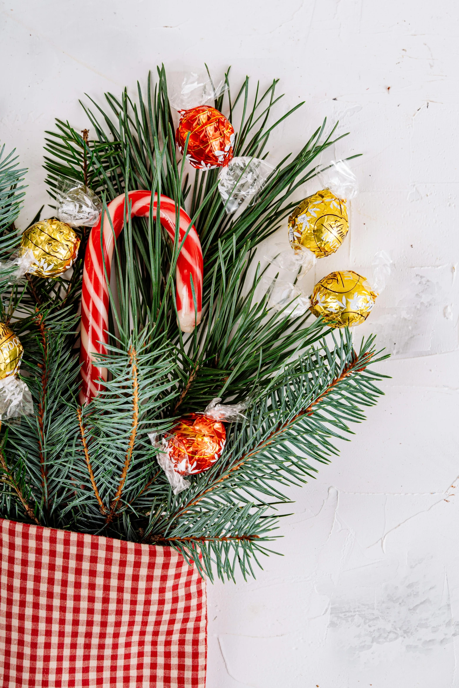 a christmas stocking filled with candy and candy canes, evergreen branches, zoomed in, bouquet, caramel