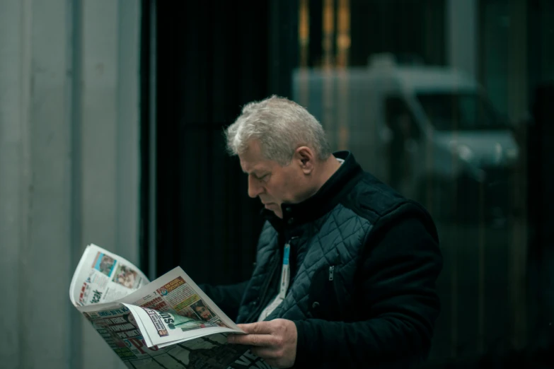 a man reading a newspaper outside of a building, a photo, by Adam Marczyński, pexels contest winner, white-haired, middle - age, leonid, photo for a magazine