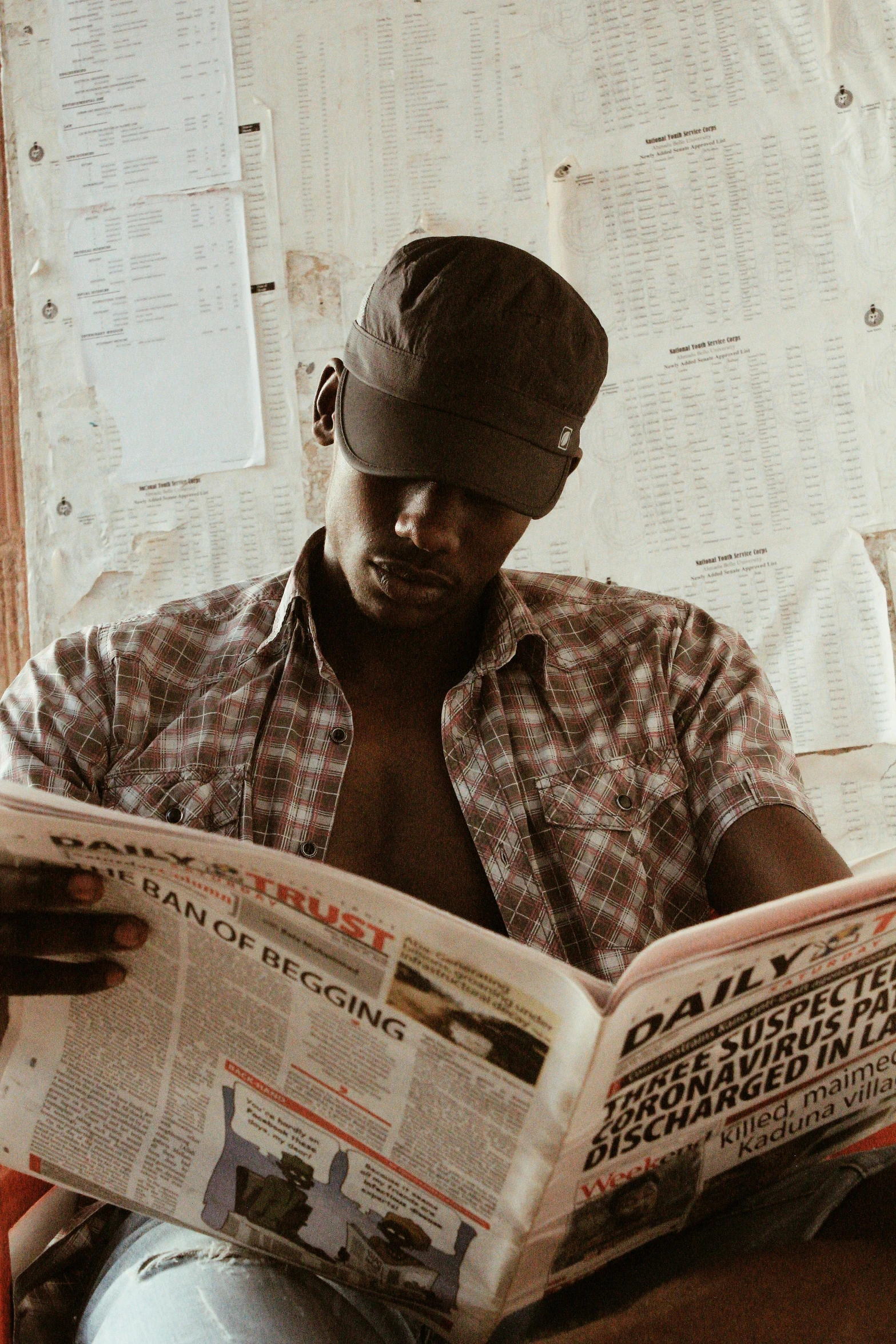 a man sitting on a couch reading a newspaper, by Dean Ellis, pexels contest winner, afrofuturism, farmer, movie still, shady, profile pic