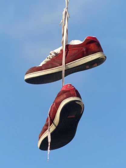 a pair of shoes hanging from a rope, by Niko Henrichon, sots art, style of tony hawk, reds, viewed from the ground, waste