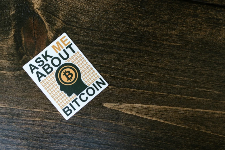 a sticker sitting on top of a wooden table, by Sam Black, unsplash, bitcoin, help me, vector sticker, 8