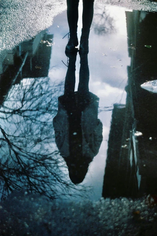 a person walking in the rain with an umbrella, an album cover, unsplash, surrealism, sitting in a reflective pool, hanging upside down from a tree, photo taken on fujifilm superia, crystallized human silhouette