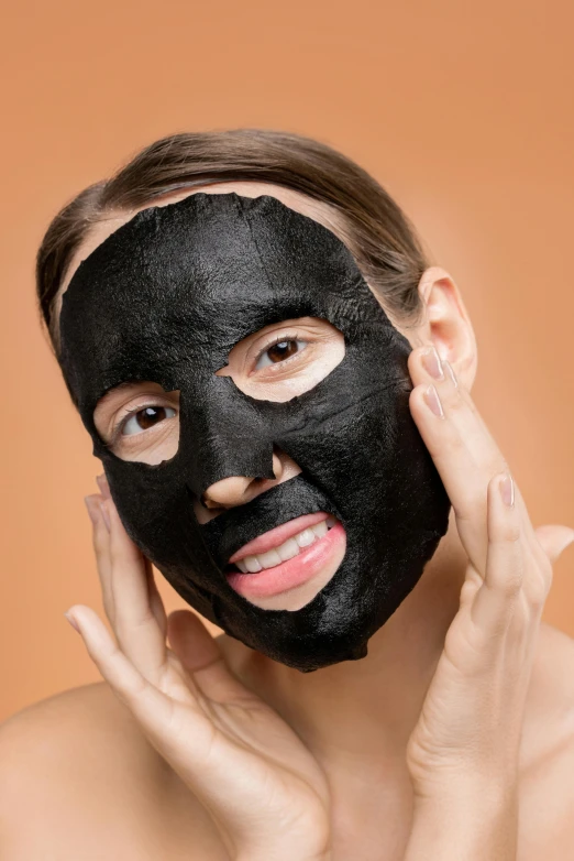 a woman with a black mask on her face, textured base ; product photos, having fun, face centered, brown