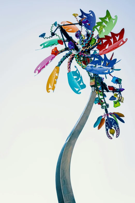 a colorful sculpture sitting on top of a metal pole, by Frances Jetter, fronds, low angle view, keys, 2 0 5 6