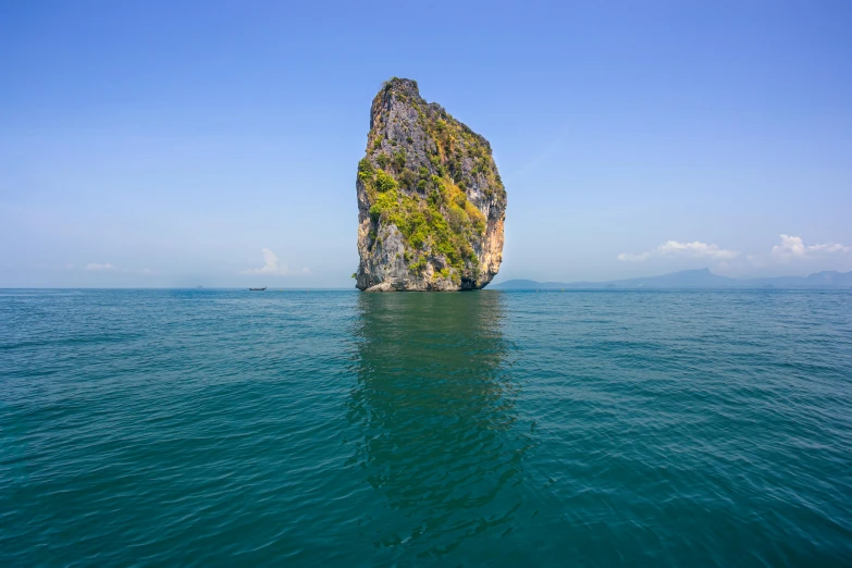 an island in the middle of the ocean, by Jan Rustem, pexels contest winner, big sharp rock, thawan duchanee, tall thin, face photo