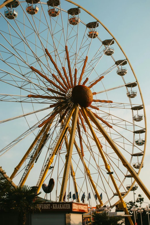 a large ferris wheel sitting in the middle of a park, by Niko Henrichon, yellow, festivals, sunfaded, budapest