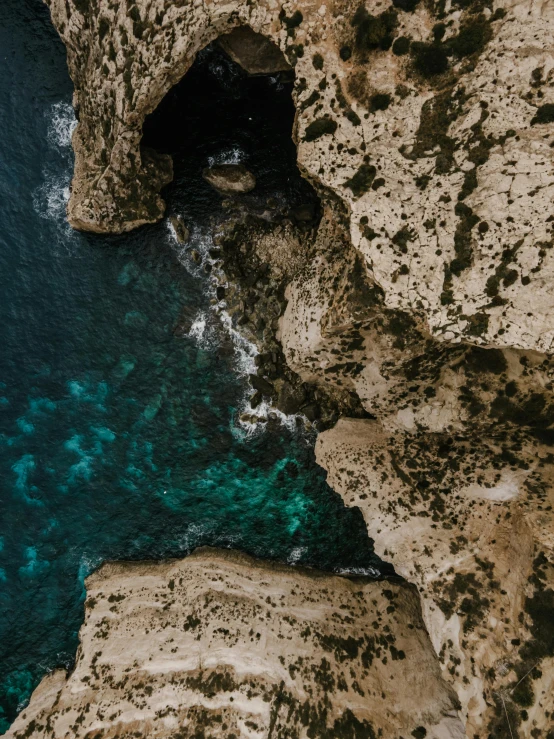 a man standing on top of a cliff next to a body of water, pexels contest winner, les nabis, close-up from above, grotto, teal aesthetic, smiling down from above