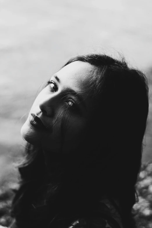 a black and white photo of a woman with long hair, pexels contest winner, woman's face looking off camera, sadness personified, woman with black hair, light falling on face