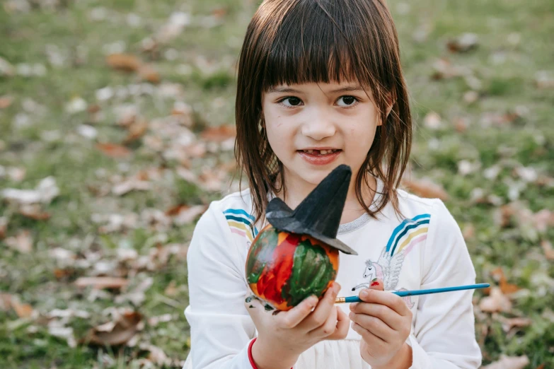 a little girl holding a lollipop in her hands, a child's drawing, pexels contest winner, pointy witch hat, she is a gourd, model painting, youtube thumbnail