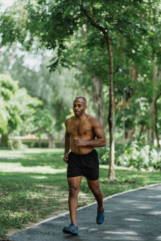 a man running on a path in a park, inspired by Ma Quan, happening, of a shirtless, malaysian, profile image, black man