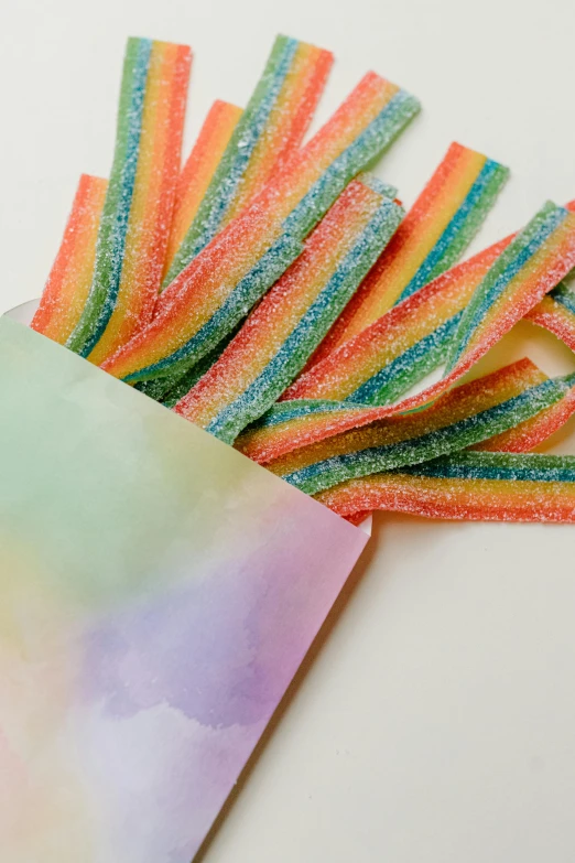 a bunch of gummy sticks sitting on top of a piece of paper, infused with aurora borealis, pouches, medium closeup, ribbon