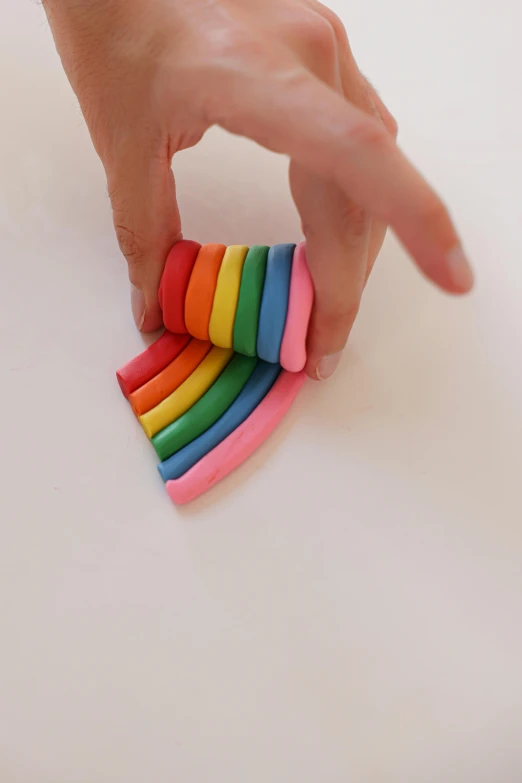 a close up of a person holding a piece of cake, muted rainbow tubing, made of clay, play - doh, overview