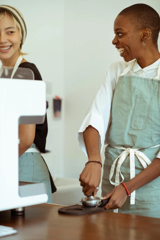 a couple of women standing next to each other in a kitchen, by Lee Loughridge, trending on unsplash, renaissance, starbucks aprons and visors, robots queue up for ice cream, white apron, thumbnail