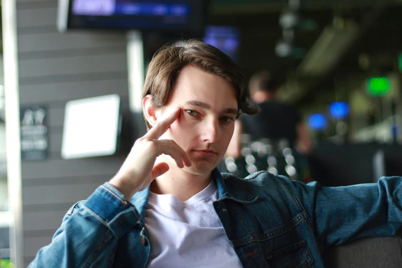 a close up of a person sitting on a couch, a portrait, unsplash, photorealism, gambling, caleb from critical role, f 1 driver charles leclerc, casual pose