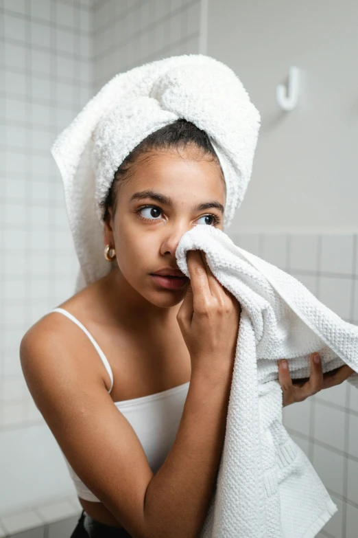 a woman wiping her face with a towel, trending on pexels, process art, tan skin, teenage girl, bumps, 9