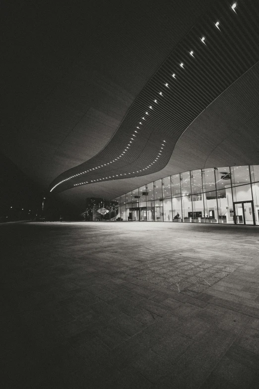 a black and white photo of a building at night, inspired by Zha Shibiao, unsplash contest winner, bus station, large hall, beautiful!!!! museum photo, exterior
