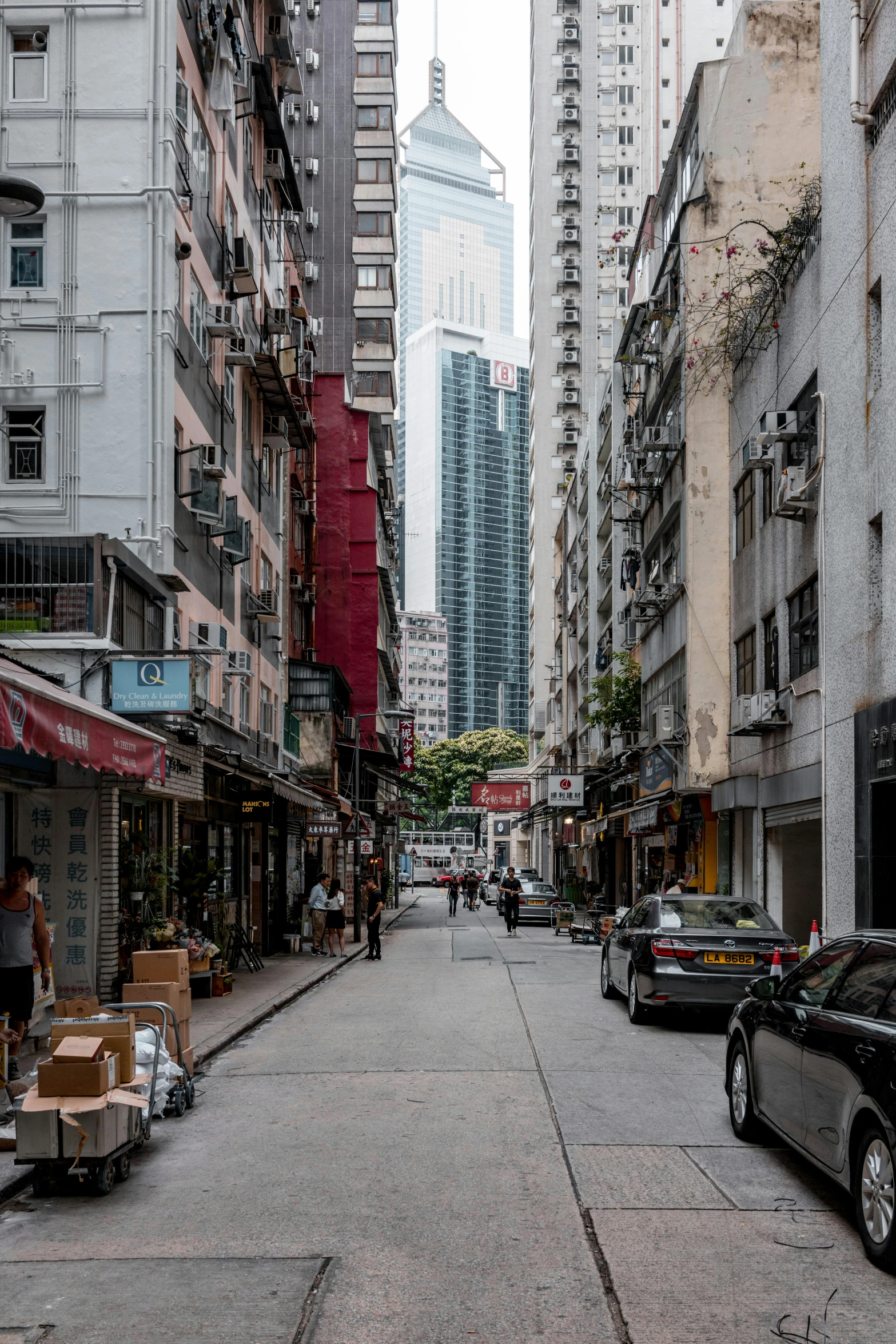 a city street filled with lots of tall buildings, shkkeled in the voied, ben lo, shady alleys, street photo