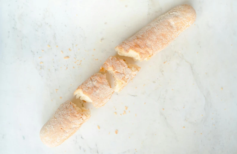 a long piece of bread sitting on top of a counter, citrinitas, sleek white, thumbnail, battered