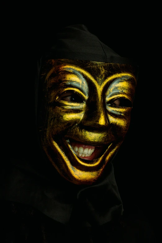 a man wearing a mask in the dark, an album cover, inspired by Hedi Xandt, pexels contest winner, laughing and joking, gold paint, spooky filter, avatar image