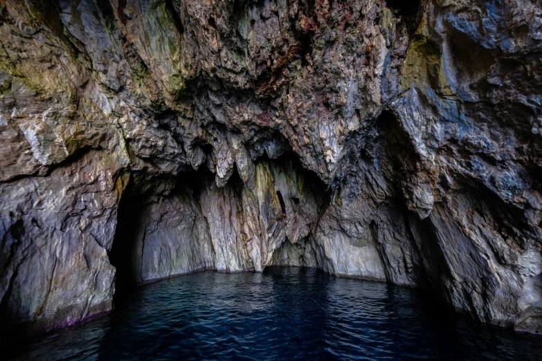 a cave in the middle of a body of water, colour photo, scotland, fan favorite, thumbnail