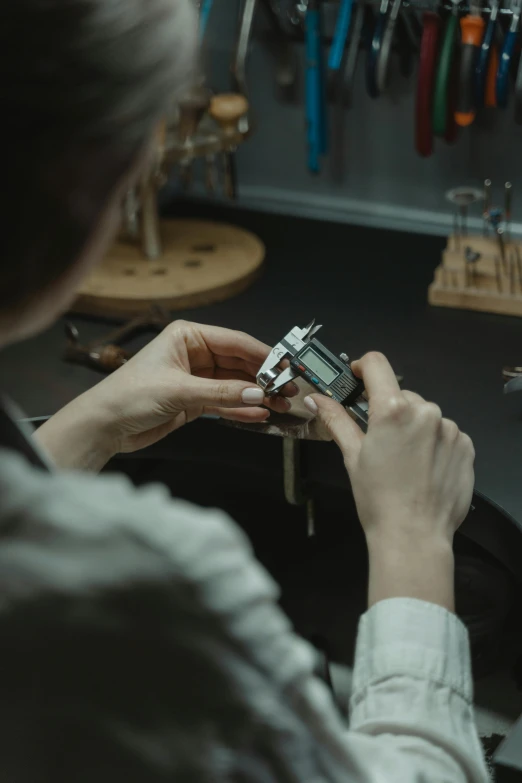 a woman working on a watch in a workshop, by Mathias Kollros, curated collections, digital image, premium quality, mini model