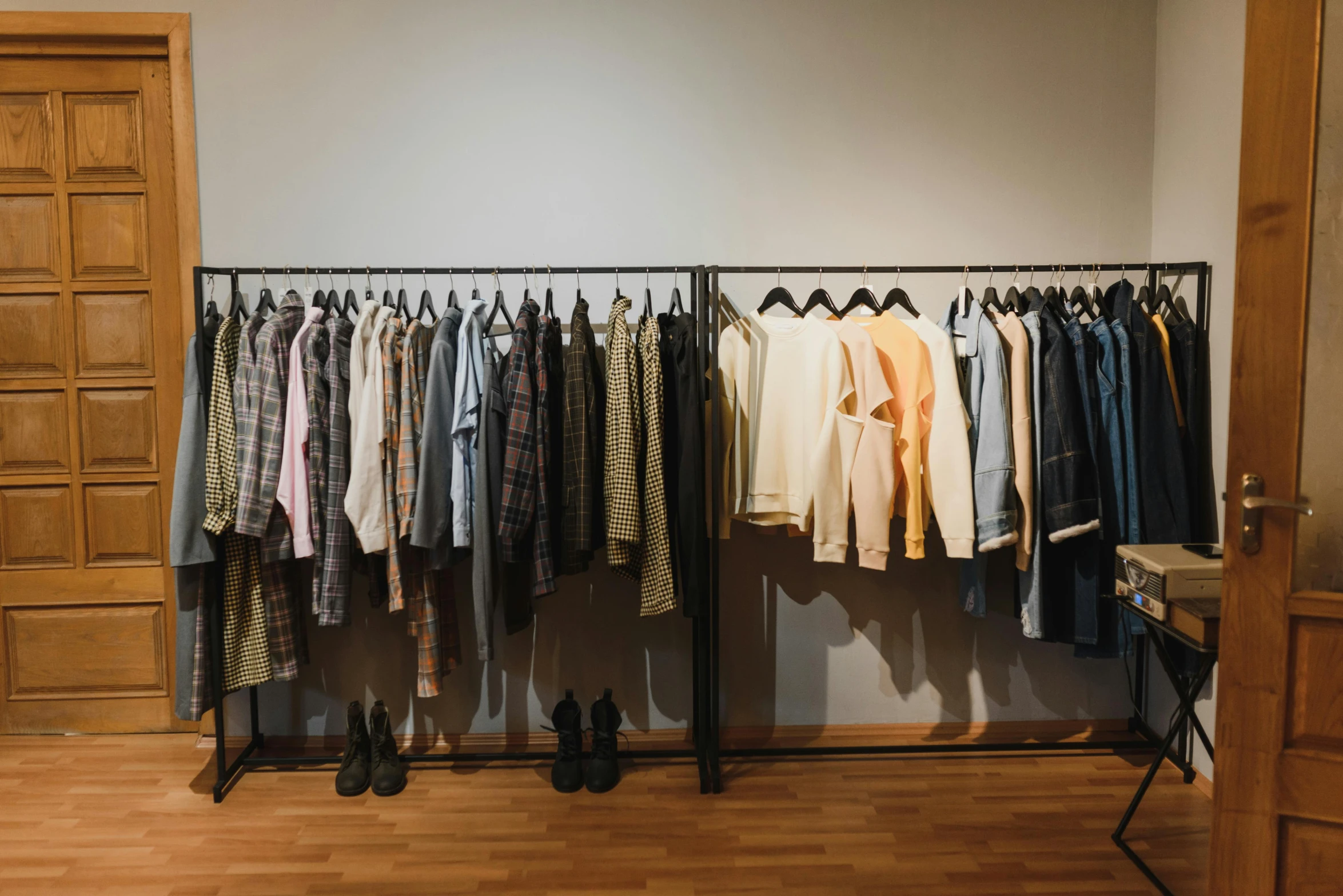 a rack of clothes sitting on top of a wooden floor, a photo, trending on unsplash, hurufiyya, evenly lit, product showcase, 90's photo, long shirt