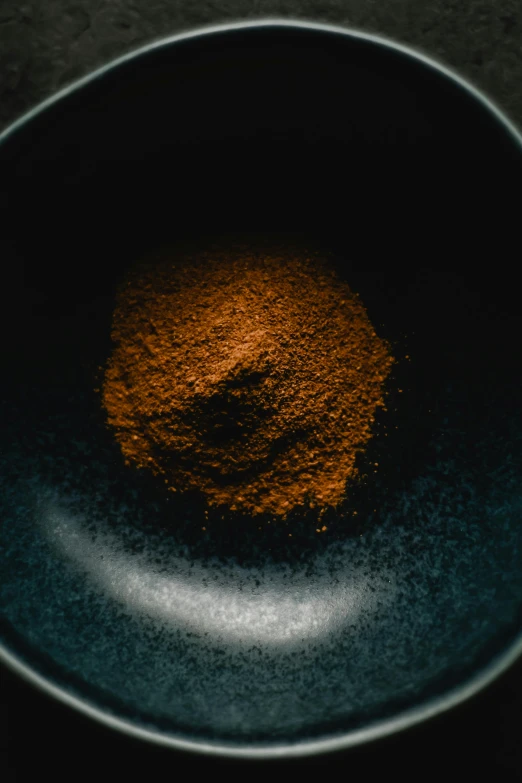 a close up of a bowl of food on a table, a macro photograph, unsplash, australian tonalism, powder, brown, spicy, vantablack