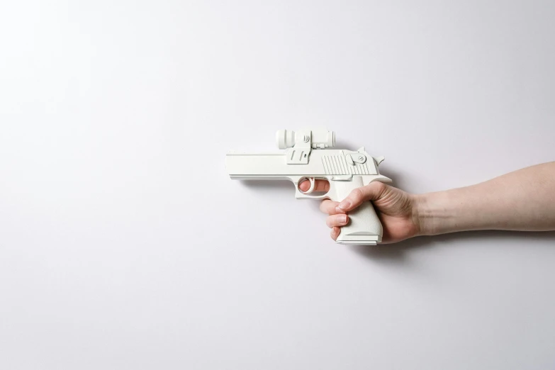 a close up of a person holding a toy gun, by jeonseok lee, white finish, paper, white backdrop, easy to use