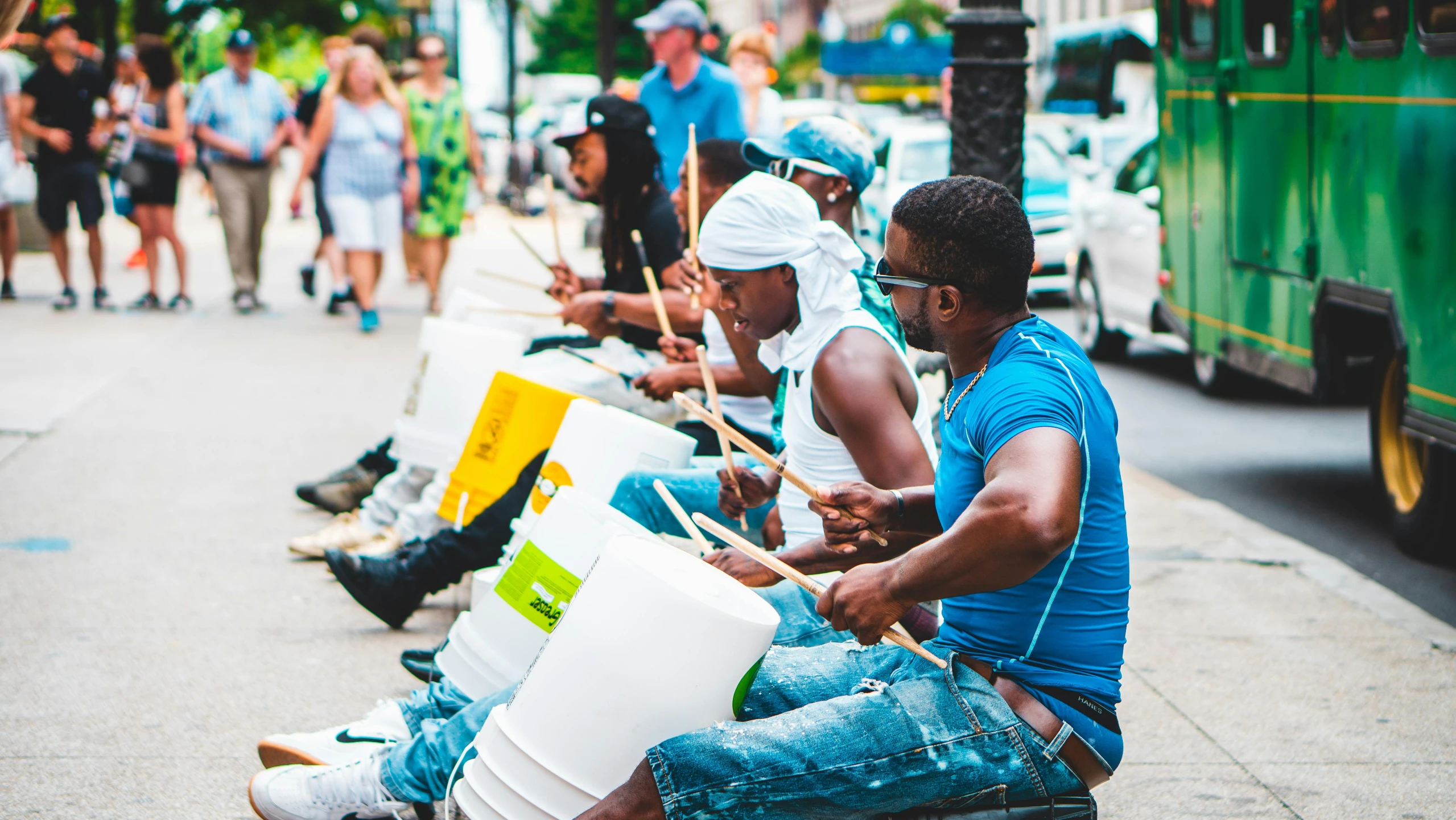 a group of men sitting on the side of a street, pexels contest winner, black arts movement, drum pads, chicago, a green, thumbnail